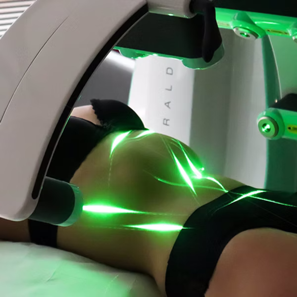 Emerald Laser device positioned over a client’s midsection.