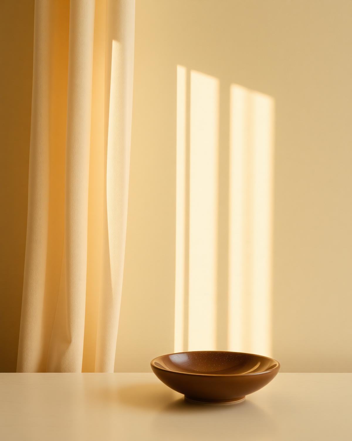 Daylight through a sheer curtain casting soft shadow on a plaster wall